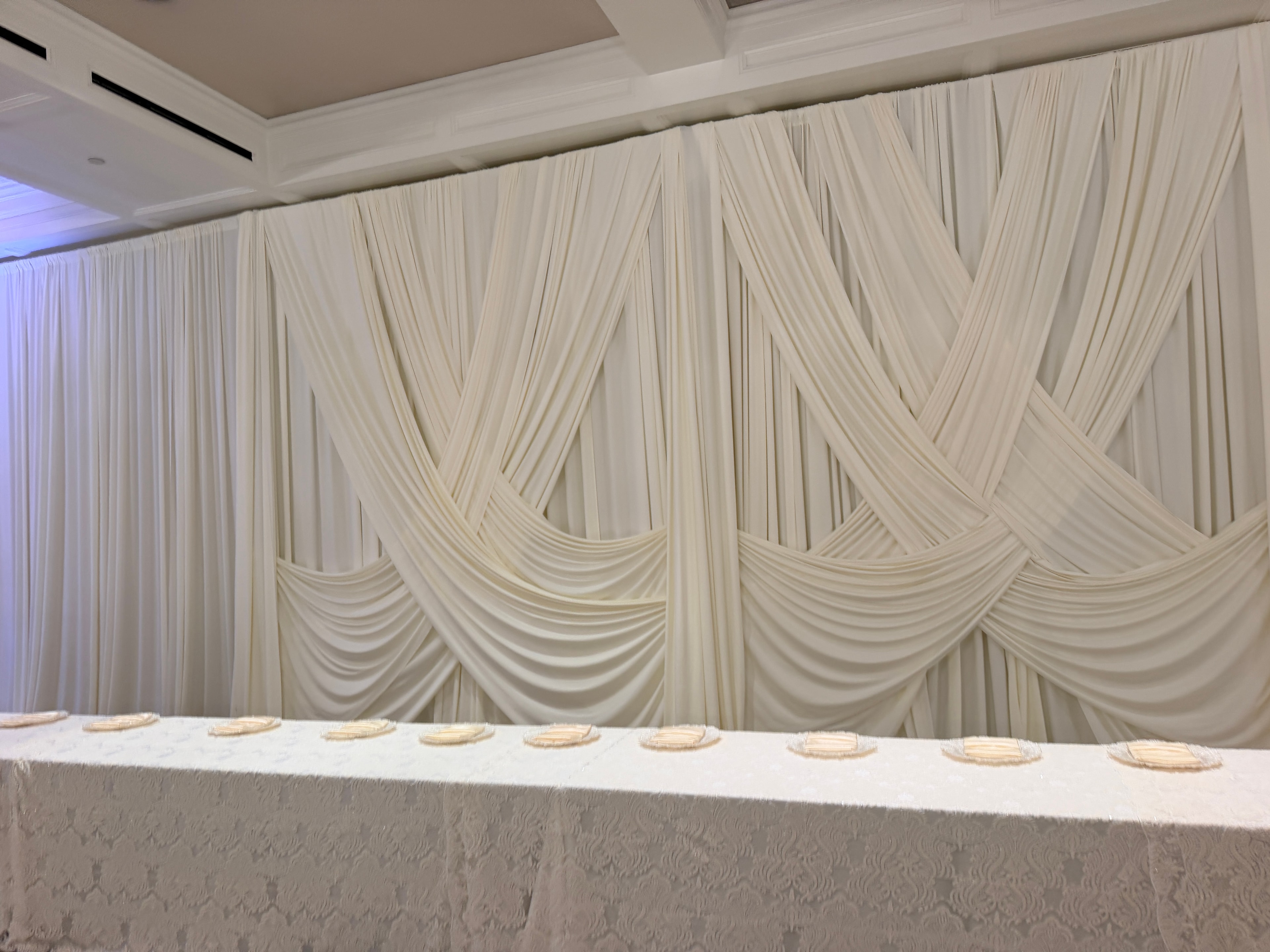 Ivory crossover swag backdrop drape with lace head table linen at a Metro Detroit wedding